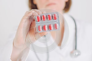 Female doctor offering red tablets to patient