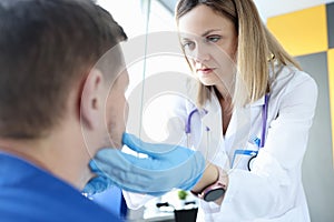 Female doctor palpating patients submandibular lymph nodes