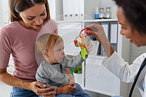 Female doctor pediatrician with baby patient and mother