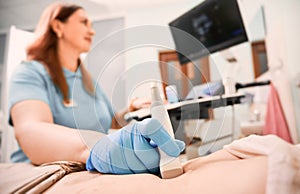 Female doctor performing ultrasound procedure in clinic.