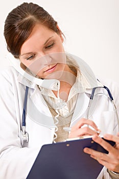 Female doctor on the phone with medical file