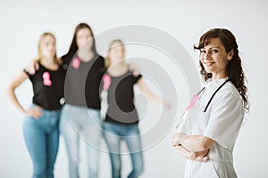 Female doctor with pink bow standing in front of patients