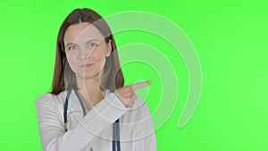 Female Doctor Pointing on Side on Green Background