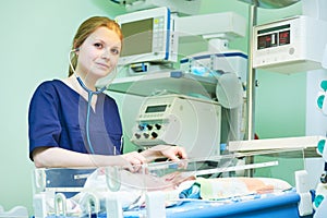 Female doctor portrait in front of intensive care unit for newborn infant baby