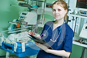 Female doctor portrait in front of intensive care unit for newborn infant baby