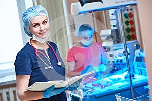 Female doctor portrait in front of intensive care unit for newborn infant baby