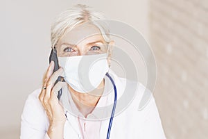 Female doctor portrait while wearing face mask and working at the doctor`s office