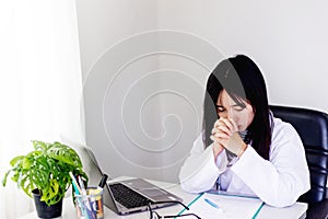 Female doctor praying before work