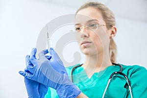 Female doctor prepares syringe to vaccinate