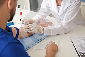 Female doctor preparing patient for blood draw in clinic