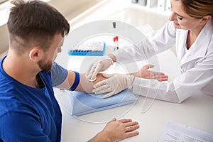 Female doctor preparing patient for blood draw in clinic