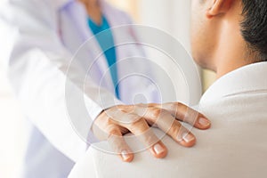 Female doctor put hand on patient shoulder for encouragement