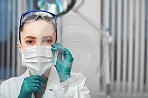 Female doctor puts on a mask, fight against the virus, personal protective equipment, masks, glasses, gloves. The