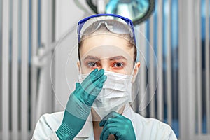 Female doctor puts on a mask, fight against the virus, personal protective equipment, masks, glasses, gloves. The