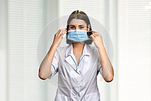 Female doctor putting on face mask.