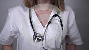 Female doctor putting stethoscope around her neck