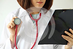 Female doctor reading a patient treatment chart.