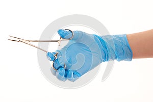 Female doctor's hand in blue sterilized surgical glove with forceps