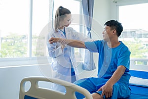 Female doctor's hand doing physiotherapy stretching the shoulder of a male patient.