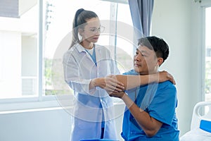 Female doctor's hand doing physiotherapy stretching the shoulder of a male patient.