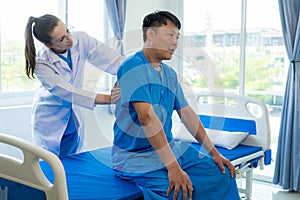 Female doctor's hand doing physiotherapy stretching the shoulder of a male patient.