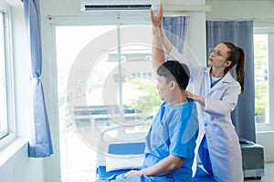 Female doctor's hand doing physiotherapy stretching the shoulder of a male patient.