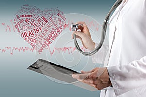 Female doctor's hand holding stethoscope and clipboard on blurre