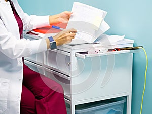 Female doctor's hands fill out medical documents