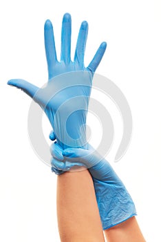 Female doctor's hands putting on blue sterilized surgical gloves