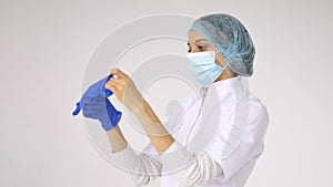 Female doctor's hands putting on blue sterilized surgical gloves in the medical clinic for some medical manipulations