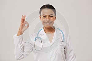 Female Doctor Showing OK Posing on White