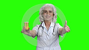 Female doctor showing pills and thumb up.