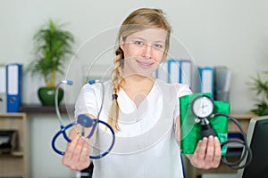 female doctor showing stethoscope and blood meassuring tool photo