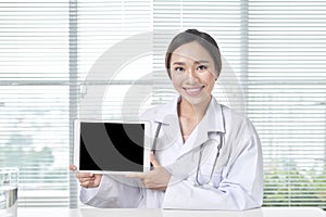 Female doctor showing tablet with blank screen to patient at office