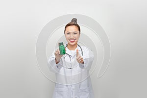 female doctor shows jar of pills and thumb