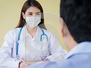 A female doctor is smiling face under the surgical mask and looking to male patients