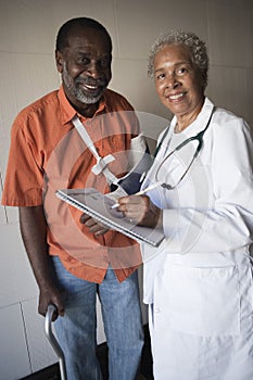 Female Doctor Standing With Disabled Patient