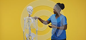 Female doctor standing by a skeleton