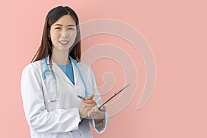 Female doctor standing at work in hospital with lab coat and stethoscope holding medical folder in hand