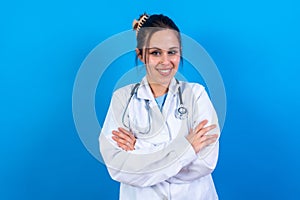 Female doctor stands confidently with her arms folded, looking directly at the camera