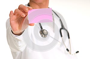 Female doctor with stethoscope holding a pink note