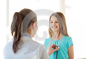 Female doctor with stethoscope listening to child