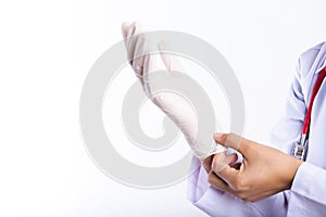 Female doctor with a stethoscope on one shoulder putting on sterile gloves. Healthcare And Medical concept