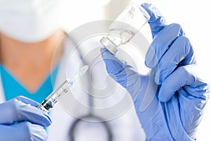 Female doctor with a stethoscope on shoulder holding syringe and photo