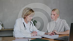A female doctor studies the medical history of a young attractive woman