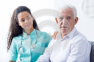 Female doctor supporting senior man