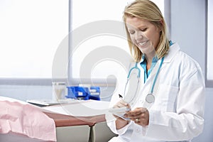 Female Doctor In Surgery Writing Out Prescription