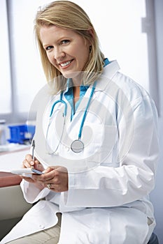 Female Doctor In Surgery Writing Out Prescription