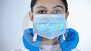 Female doctor in surgical face mask close-up, professional medical care, trust photo