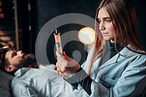 Female doctor with syringe against male patient